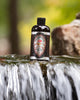 A bottle of pine tar body wash standing in a stream.