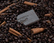 An exfoliating pine tar scrub bar sits in a coffee beans.
