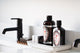 Pine tar shampoo, body wash, and bar soap sit in a bathroom tray.